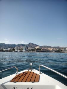 a wooden seat on the back of a boat on the water at SWEET HOME BENALMADENA Estudio para NO FUMADORES con vistas al mar y excelente conexion wifi NON SMOKING studio with sea views and excellent WiFi Enjoy plenty of morning sun in Benalmádena