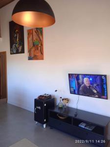 a living room with a flat screen tv on a wall at A Casa Azul - Igatu in Igatu