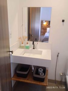 a bathroom with a white sink and a mirror at A Casa Azul - Igatu in Igatu