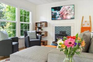 a living room with a fireplace and a vase of flowers at Mi Corazon Hot Tub Walk to River Yoga Studio in Guerneville