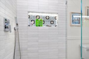a white tiled bathroom with a shower with a window at Mi Corazon Hot Tub Walk to River Yoga Studio in Guerneville +26 photos