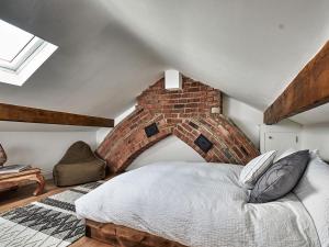 a bed in a room with a brick wall at Hill Street in Colne