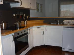 a kitchen with white cabinets and a sink at Residence des Pecheurs in Cap d'Agde