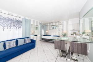 sala de estar con sofá azul y cama en Apartments on Collins, en Miami Beach