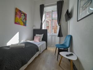 a bedroom with a bed and a chair and a window at Hotel Amager in Copenhagen