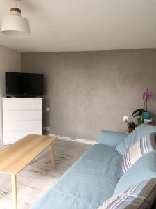 a living room with a couch and a table at Charmant séjour à Andernos in Andernos-les-Bains