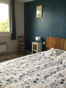 Schlafzimmer mit einem Bett mit blauer Wand in der Unterkunft Charmant séjour à Andernos in Andernos-les-Bains