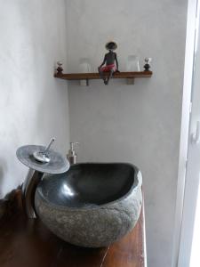 La salle de bains est pourvue d'un lavabo en pierre et d'une baignoire noire. dans l'établissement La Santijohannaise, à Saint-Jean-Kourtzerode