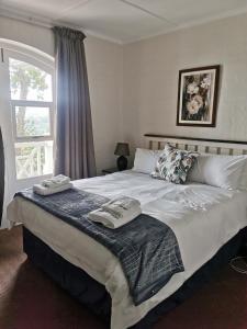 a bedroom with a large bed with two towels on it at 20 Montego Bay - Caribbean Estates in Port Edward