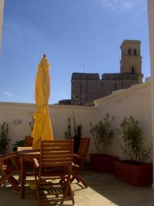patio con tavolo, sedie e ombrellone di B&B Archidamo a Manduria
