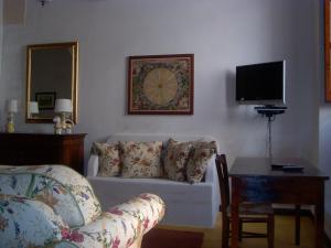 un soggiorno con divano, tavolo e TV di B&B Archidamo a Manduria