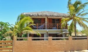 une maison derrière une clôture avec des palmiers dans l'établissement Kanaloa Village 02, à Icaraí