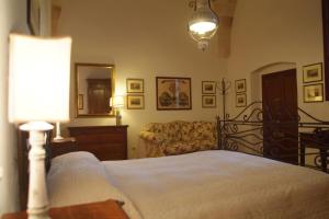 マンドゥーリアにあるB&B Archidamoのベッドルーム(ベッド1台、ソファ、ランプ付)