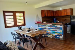 Una cocina con una mesa de madera con sillas y una cocina con estufa. en Kanaloa Village 02, en Icaraí