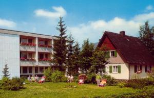 ein Haus und ein Gebäude mit Stühlen im Hof in der Unterkunft Pension Wölfel in Bad Steben