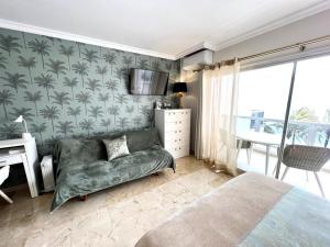 a bedroom with a couch and a tv and a bed at Las Palmas 3 in Marbella