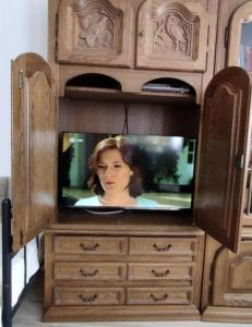 a tv sitting in a wooden entertainment center at FeWo 1 im ehemaligen Geschenkehaus in Monschau