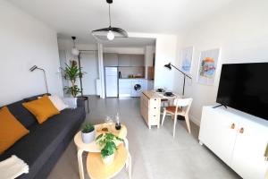 ein Wohnzimmer mit einem Sofa und einem Tisch in der Unterkunft Antibes centre, 2P refait à neuf, terrasse, garage in Antibes