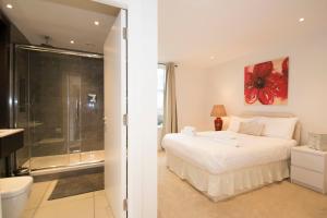 a bedroom with a large bed and a bathroom at Grand Apartments Kew Gardens in London