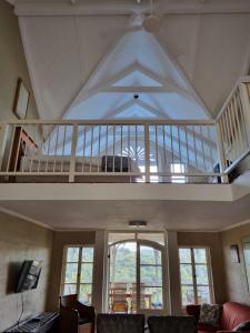 a living room with a vaulted ceiling and a staircase at 20 Montego Bay - Caribbean Estates in Port Edward
