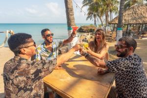 a group of people sitting at a table with drinks at La Playita Isla Fuerte in Puerto Limón