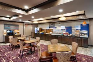 a restaurant with tables and chairs and a counter at Holiday Inn Express Hotel & Suites Billings, an IHG Hotel in Billings