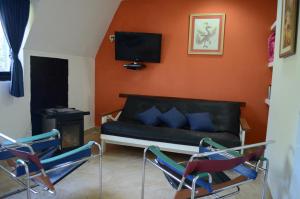 - un salon avec un canapé et deux chaises dans l'établissement Apart Hotel La Busqueda, à Moquehue