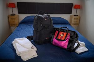 Una cama con una mochila y toallas. en VIÑAS ALTAS en Maipú