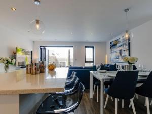 a kitchen and living room with a table and chairs at Nursery Mews in Whitstable