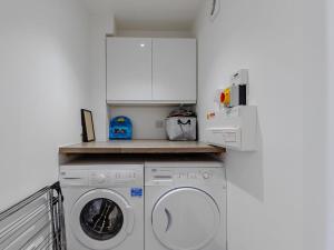 eine Küche mit einer Waschmaschine und einer Mikrowelle in der Unterkunft Nursery Mews in Whitstable
