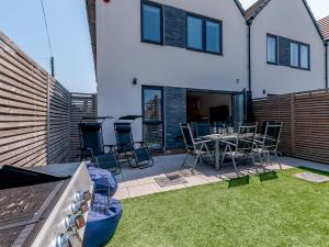 a patio with a table and chairs in a backyard at Nursery Mews in Whitstable