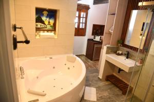 baño con bañera grande y lavamanos en Hotel Cacique Real, en Zipaquirá
