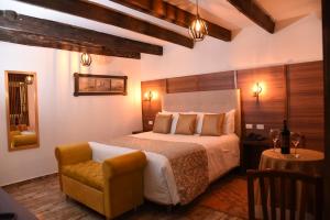 um quarto com uma cama grande e uma cadeira em Hotel Cacique Real em Zipaquirá