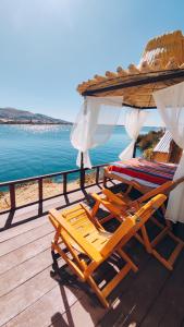 two lounge chairs on a deck with a view of the ocean at Uros Utasa Lodge in Puno