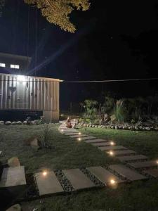 einen Garten in der Nacht mit Lichtern auf dem Rasen in der Unterkunft Wabi Sabi , beach home in Tamanique