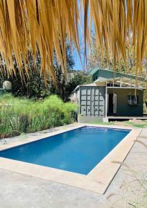 Tamanique的住宿－Wabi Sabi , beach home，一座房子前面的蓝色小游泳池