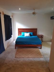 a bedroom with a bed with blue sheets and a rug at Santuario Jungle in Akumal