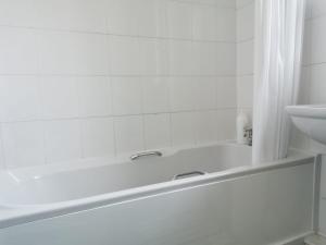 eine weiße Badewanne im Bad mit Waschbecken in der Unterkunft Victoria's Apartment - 3 Large Bedroom in Blackpool