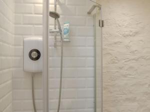 een douche met een douchekop in de badkamer bij The Chaff House in Wookey