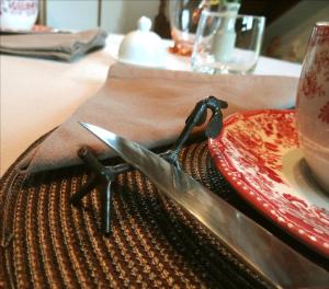 ein Messer auf einem Tisch neben einem Teller in der Unterkunft Le Chemin d'Ulphe in Boves