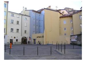 um grupo de edifícios com uma vedação à sua frente em Urban Hotel Design em Trieste