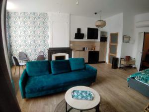 un salon avec un canapé bleu et une table dans l'établissement A l ombre des remparts 3, à Carcassonne