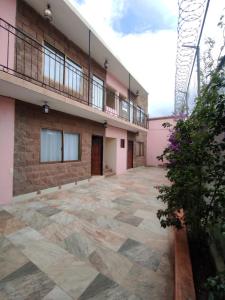 an empty courtyard of a building with a balcony at La Casa Rosa Guanajuato in Guanajuato