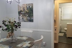 a dining room table with a vase of flowers on it at BLUE FLAMINGO'S CHARMING HOME-Heart of Tulsa2- Cherry St-Expo-11th in Tulsa