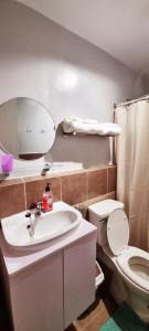 a bathroom with a sink and a toilet and a mirror at Mikaela's Crib- 1 Bedroom flat @ Arezzo Place Condominium in Davao City