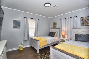 a bedroom with two beds and a window at BLUE FLAMINGO'S CHARMING HOME-Heart of Tulsa2- Cherry St-Expo-11th in Tulsa