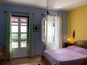 um quarto com uma cama, uma janela e uma porta em Panorama Apartments em Marathokampos