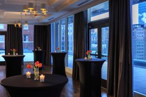 Habitación con ventanas grandes y mesas con flores. en Kimpton Hotel Monaco Pittsburgh, an IHG Hotel, en Pittsburgh