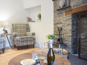 a living room with a table with a bottle of wine at The Old Smithy in Llangunllo