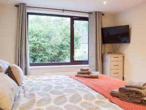 a bedroom with a bed and a large window at The Old Smithy in Llangunllo